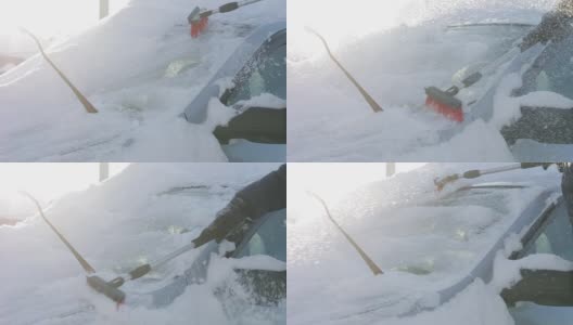 在阳光明媚的冬日，一名男子正在清理汽车上的积雪，这是反常的降雪和气候变化高清在线视频素材下载