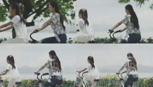夏季，亚洲母女在海滨散步道上骑自行车高清在线视频素材下载