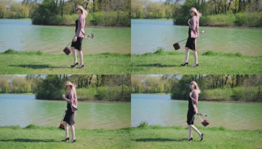 一位穿着办公服装的年轻女子，手里拿着手提包，戴着眼镜，心满意足地走在公园湖边的草地上。高清在线视频素材下载
