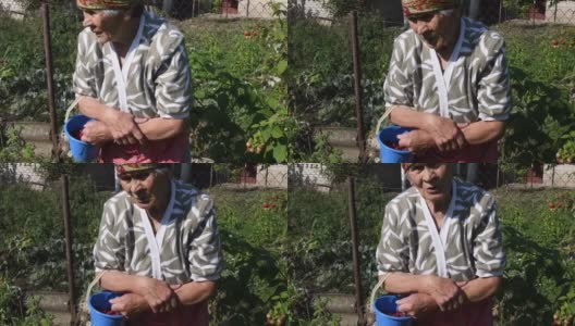 疲惫的奶奶满脸皱纹，站在菜园子里说话高清在线视频素材下载