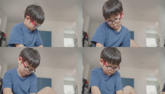 肖像可爱的亚洲学龄前儿童小男孩与眼镜玩玩具在客厅在家里高清在线视频素材下载