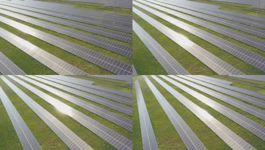 现场安装的一排排太阳能电池板。航拍可再生绿色能源的太阳能发电站。太阳能电池板表面的太阳反射。生产清洁生态能源。近距离高清在线视频素材下载