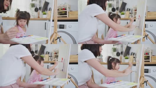 亚洲年轻快乐的女儿和妈妈在画板上画画。快乐的家庭活动，小女孩学习如何用水彩画和画笔画画，享受与妈妈的创造力。高清在线视频素材下载