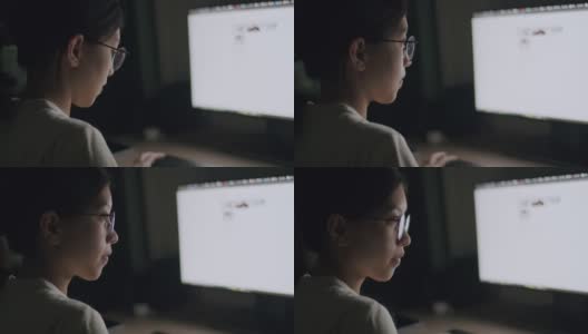 亚洲女性戴着眼镜，利用电脑搜索网上信息，为晚上的工作计划做准备。高清在线视频素材下载