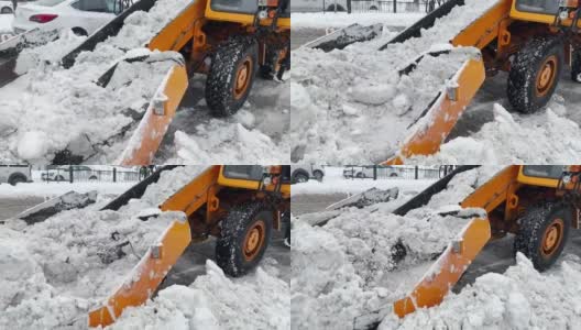 挖掘机，一辆汽车在清理城市街道上的积雪高清在线视频素材下载