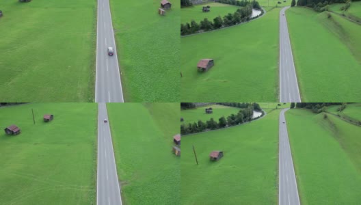 在奥地利的绿色田野之间的道路在一个高山村庄，鸟瞰图高清在线视频素材下载