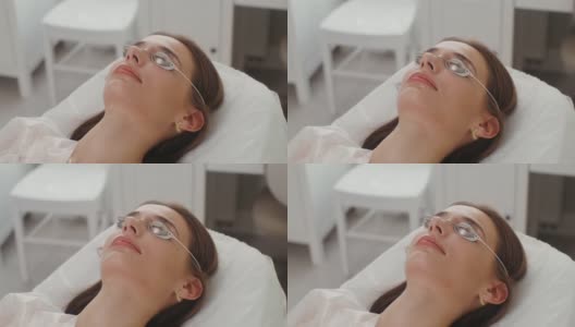 一位戴着防护眼镜的女病人躺在美容院的房间里高清在线视频素材下载