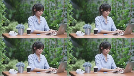 亚洲年轻女子坐在工作场所，在花园里使用笔记本电脑高清在线视频素材下载