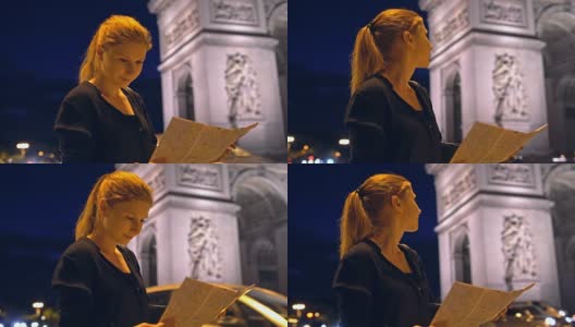 带着巴黎城市地图的游客在夜间欣赏凯旋门纪念碑高清在线视频素材下载