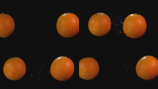 在黑色的背景下，橙色的水滴相互碰撞高清在线视频素材下载