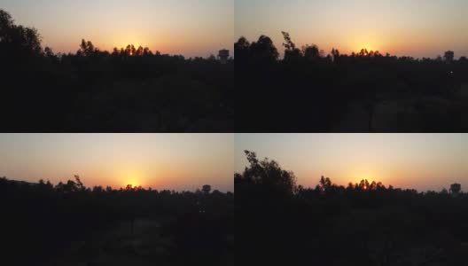日落橘黄色，彩色的戏剧性天空鸟瞰图与树的阴影在晚上高清在线视频素材下载