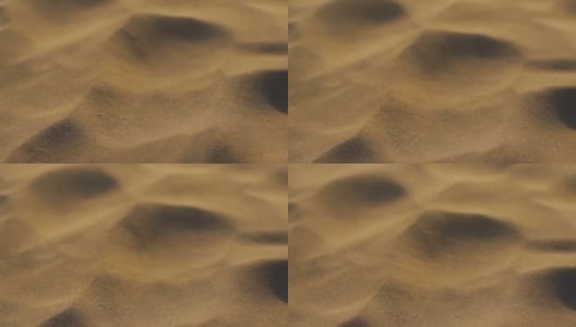 印度拉贾斯坦邦Jaisalmer的塔尔沙漠的山姆沙丘上，沙丘上的沙尘在空中流动的慢动作特写镜头。沙漠中由于风而在空气中流动的沙粒。高清在线视频素材下载