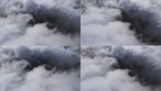 高空鸟瞰图，远处的城市被暴雨前形成的蓬松的积云所覆盖。飞机角度多云的景观高清在线视频素材下载