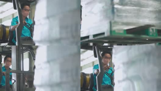 亚洲华人男性仓库工人，带着口罩在工业工厂操作叉车高清在线视频素材下载