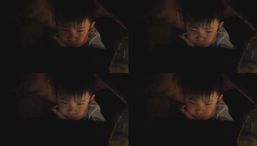 一个小男孩在晚上学习使用药片高清在线视频素材下载