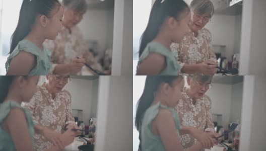 亚裔中国孙女在周末闲暇时间在厨房里跟奶奶学习烹饪技巧高清在线视频素材下载