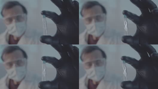 一个医生穿着长袍，戴着橡胶防护手套，拿着一个研究用的安瓿。这个实验室工作人员的脸被弄模糊了。科学实验室的研究工作。高清在线视频素材下载