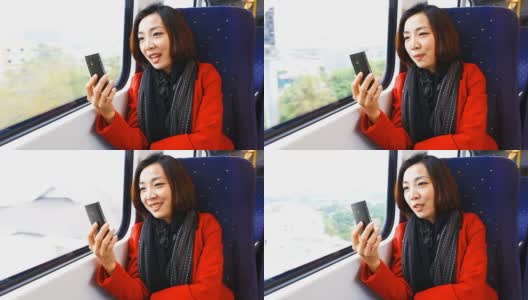 一个年轻的亚洲女人在火车上和朋友聊天。高清在线视频素材下载