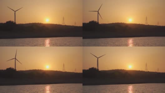 在印度古吉拉特邦的Wankaner，夕阳下的风车剪影。在黄金时段，除了太阳，还能看到风车和电塔。日落时的自然背景高清在线视频素材下载
