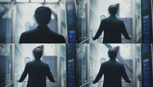 时尚的日本商人乘坐玻璃电梯到现代商务中心的办公室。从电梯的全景窗口看现代市中心的摩天大楼。转身对着镜头。高清在线视频素材下载