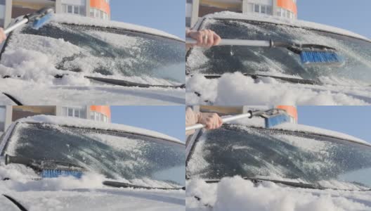 一个女人的手拿着一把刷子，从汽车挡风玻璃上扫雪高清在线视频素材下载