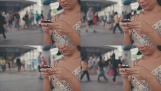 慢镜头:一名亚洲女子在城市场景中看智能手机上的信息高清在线视频素材下载