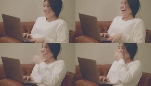 亚洲妇女看着笔记本电脑，笑得很开心高清在线视频素材下载
