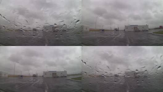 下雨天，从车窗往外看，雨点落在挡风玻璃上，停在加油站附近高清在线视频素材下载