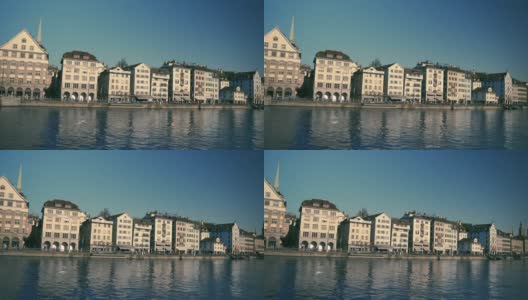 在一个阳光明媚、天空湛蓝的日子里，瑞士苏黎世州的利马特河上有著名的弗劳姆蒙斯特教堂，历史悠久的苏黎世市中心美景尽收眼底高清在线视频素材下载