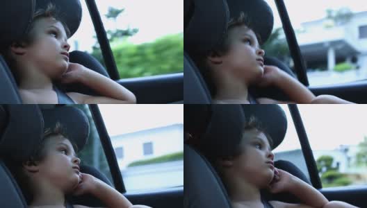 蹒跚学步的小男孩坐在车里的后座上高清在线视频素材下载