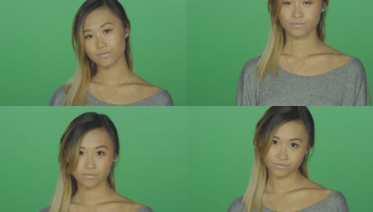 可爱的亚洲女孩怒目，在一个绿色屏幕的工作室背景高清在线视频素材下载