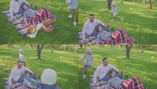 父母躺在草地上-孩子们有乐趣和跑步背景在公园高清在线视频素材下载