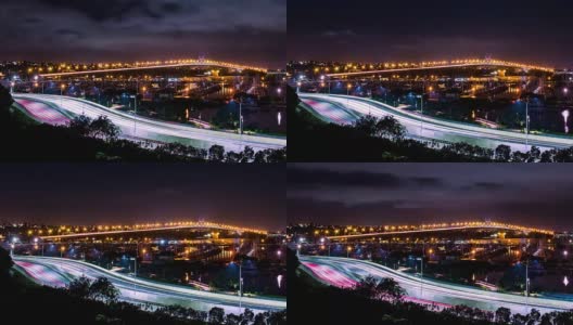 在海面上亮着灯的桥和高速公路上行驶的汽车和停泊在码头的帆船高清在线视频素材下载