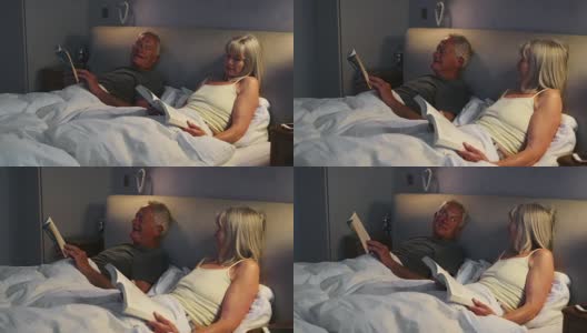 一对老夫妇穿着睡衣躺在床上看书聊天高清在线视频素材下载