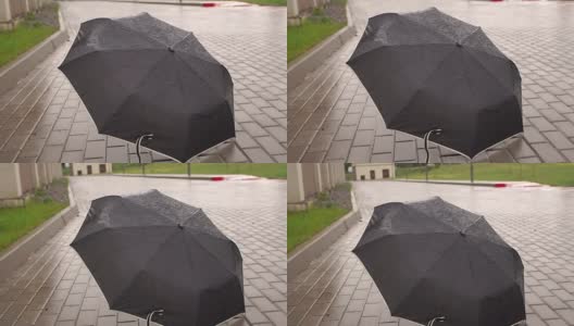 在雨中躺在路上的黑伞。高清在线视频素材下载