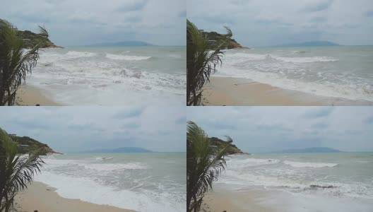 热带海滩与沉重挥舞的棕榈树在暴风雨在慢镜头。1920 x1080高清在线视频素材下载