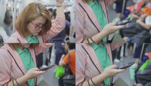 年轻女子在乘坐地铁时使用智能手机的特写高清在线视频素材下载