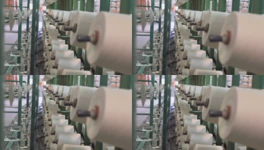 纺织厂工业整经机筒子架上的白色纱线轴高清在线视频素材下载
