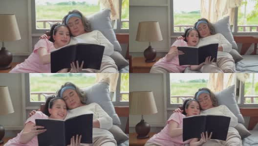 女儿给一位上了年纪的母亲读书，直到她在床上睡着。家庭中温暖的爱高清在线视频素材下载
