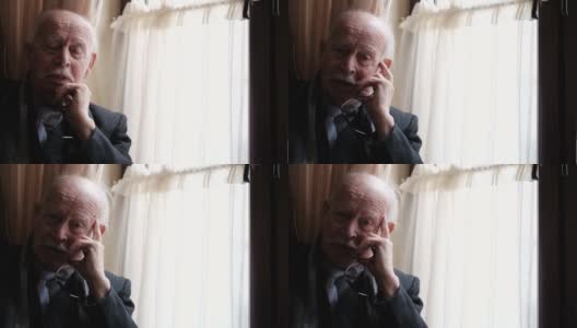 一位白发苍苍的老爷爷坐在窗边高清在线视频素材下载