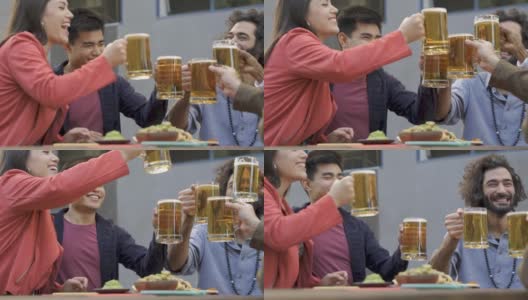 在啤酒厂酒吧，多种族的人们在户外喝着啤酒欢呼高清在线视频素材下载