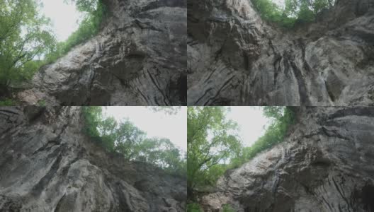 在直立的岩壁上的圆周运动，岩壁上生长着植被高清在线视频素材下载
