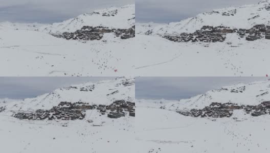 雪山滑雪场。令人惊叹的无人机视图小镇和滑雪场位于雪山山脊附近的冬季高清在线视频素材下载