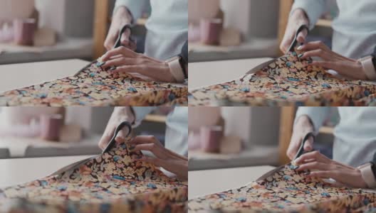 在一家服装厂，女工用剪刀切割布料的特写镜头高清在线视频素材下载