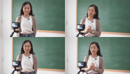微笑的亚洲女教师在线教学与摄像机在教室。她为她的学生视频博客录制视频教程。在线教育高清在线视频素材下载