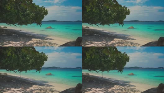 美丽的Cinemagraph /无缝视频循环在遥远的热带亚洲海滨沙滩在Perhentian岛，马来西亚一个巨大的树和充满活力的全景海景秋千。蓝天碧水，风景秀丽，是旅游度假区。高清在线视频素材下载