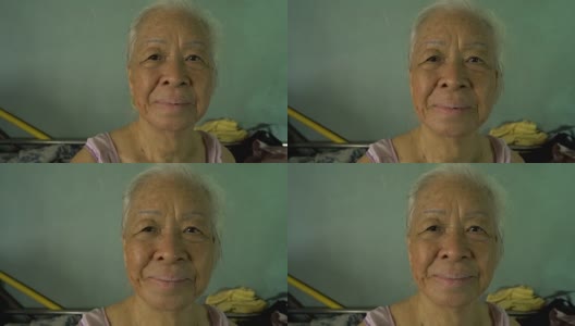 肖像高级亚洲妇女微笑的相机。高清在线视频素材下载