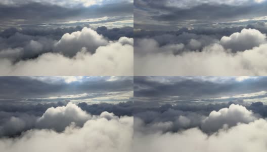 从飞机窗口高空俯瞰，在暴雨前形成的蓬松的积云覆盖着大地高清在线视频素材下载