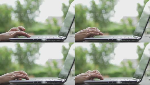 女人用绿色散焦背景的笔记本电脑键盘打字，在家工作高清在线视频素材下载