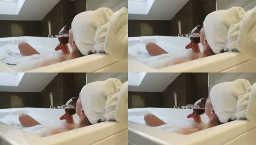 放松的女人在浴缸里喝葡萄酒高清在线视频素材下载